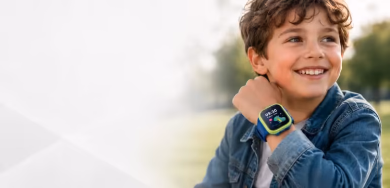 Uśmiechnięty chłopiec w dżinsowej kurtce nosi niebiesko-zielony smartwatch z kolorową tarczą.